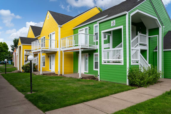 a row of colorful houses with yellow and green roofs