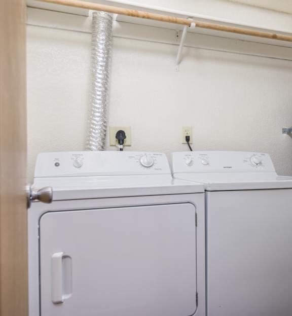 a white washer and dryer in a room with a door