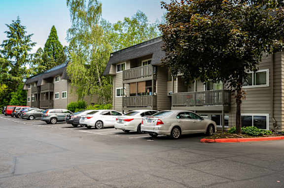A parking lot with cars and apartment buildings in the background.