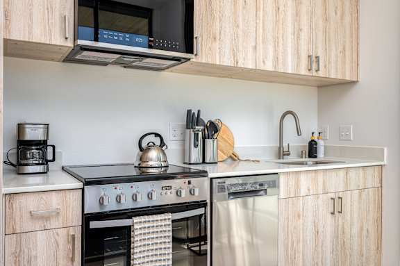 A modern kitchen with wooden cabinets and stainless steel appliances.