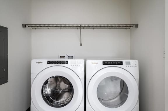 Two white washing machines in a laundry room.
