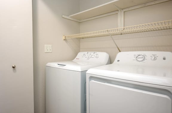 Two white front loading washing machines in a laundry room.
