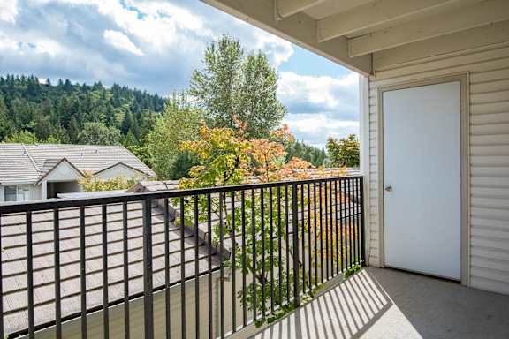 A balcony with a black railing and a white door.