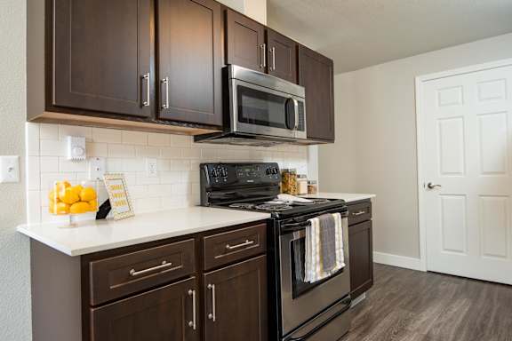 A kitchen with dark brown cabinets and a black stove top oven.