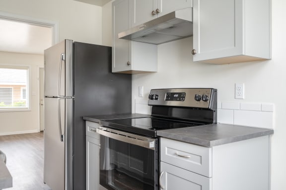 a kitchen with white cabinetry and black appliances