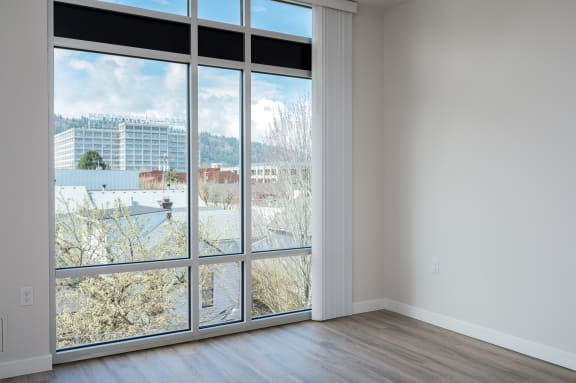 an empty room with a large window with a view of a city