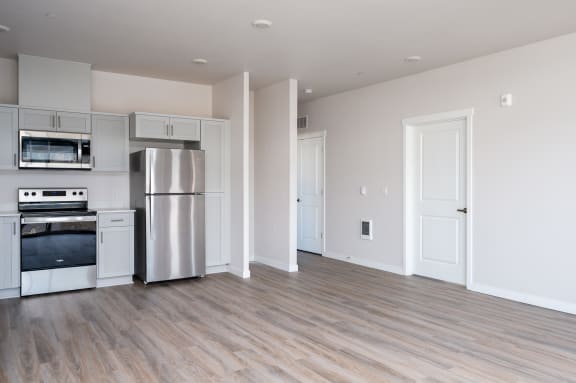 a kitchen and living room with white walls and LVP floors
