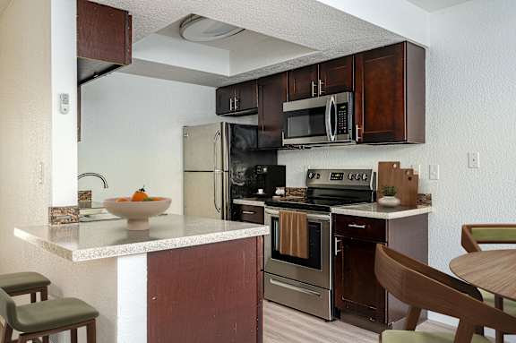A kitchen with brown cabinets and a white countertop.