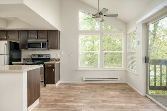 A kitchen with a white counter top and wooden floors.