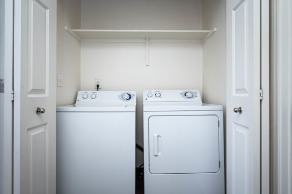 a white washer and dryer in a white laundry room