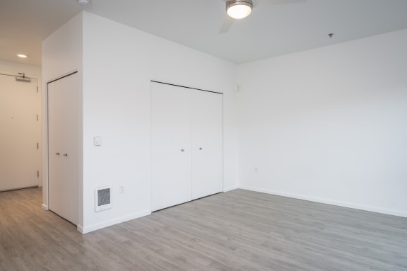 an empty room with white walls and a wood floor