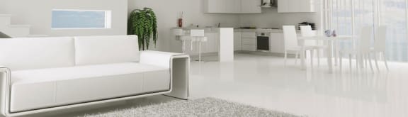 a white living room with a white couch and a white kitchen