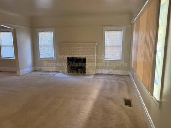 A room with a fireplace and a window.