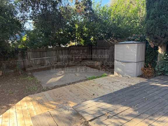 A backyard with a wooden deck and a shed.
