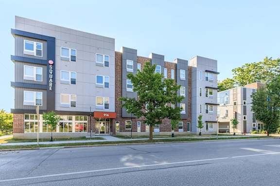 A modern apartment building with a clear blue sky in the background.