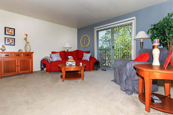 A living room with a red couch and a wooden coffee table.