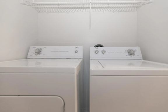 Two washing machines in a small laundry room.