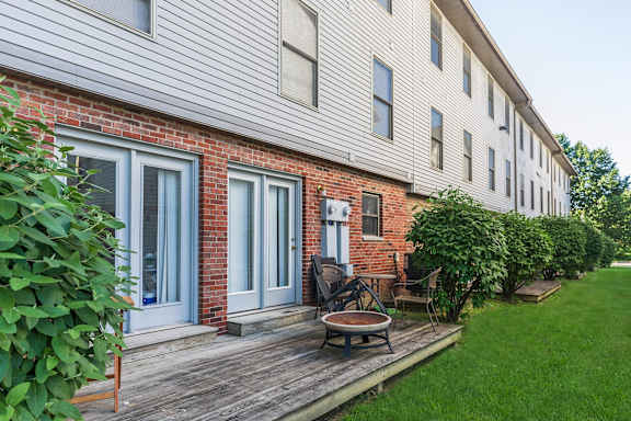 A house with a red brick wall and a wooden deck.