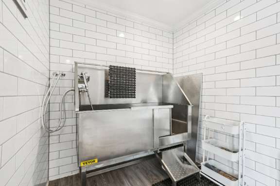 A stainless steel kitchen sink with a drainboard and a dish rack.