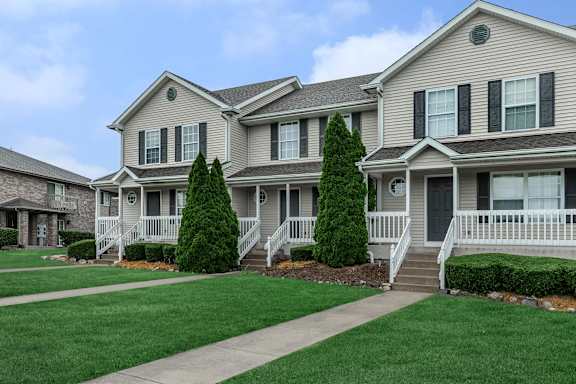 A row of houses with green lawns in front.