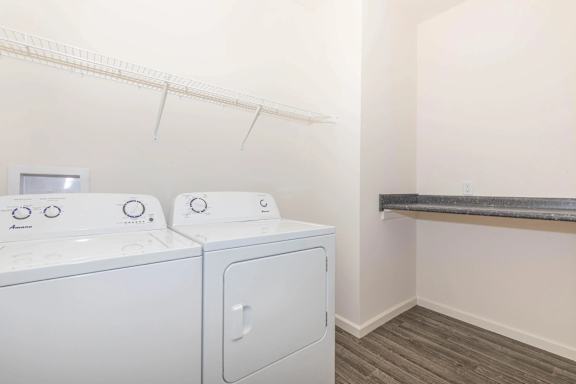 Two white front loading washing machines in a laundry room.