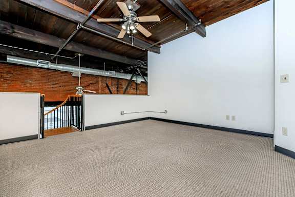 A room with a ceiling fan and a carpeted floor.