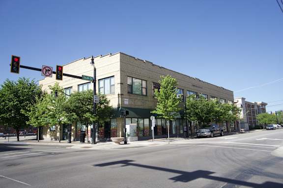A street view of a building with a traffic light showing red.