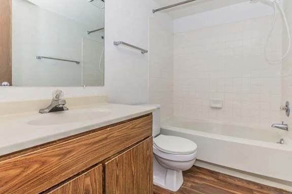 A white toilet sits next to a white bathtub in a bathroom.