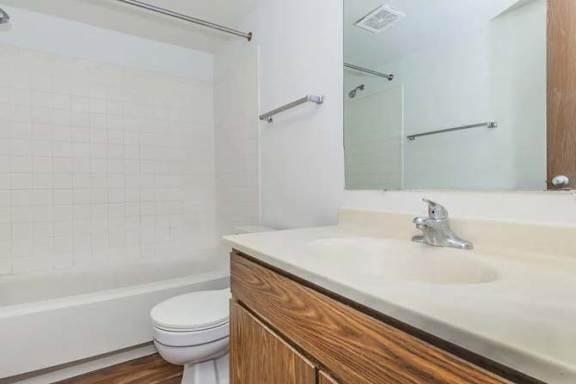 A white toilet sits next to a white sink in a bathroom.