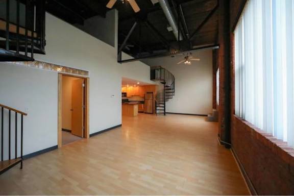 A room with wooden floors and a staircase.