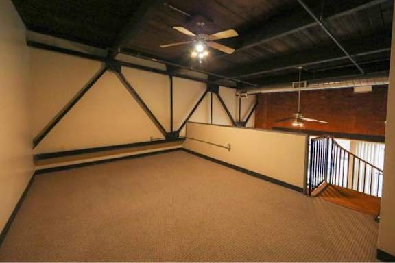 A room with a ceiling fan and a carpeted floor.