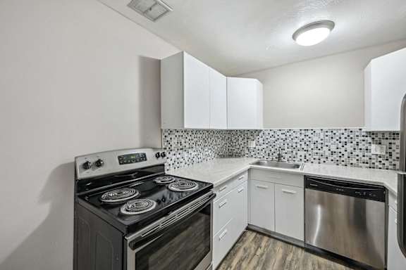 A kitchen with a black stove and white cabinets. at Park at Fitzsimons Apartments, Aurora, MO, 80011