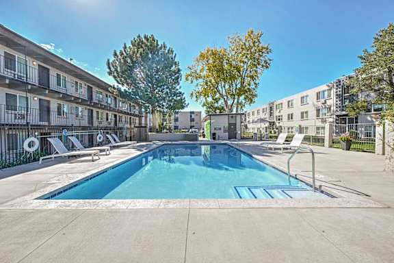 our apartments have a swimming pool and a patio with chair at Park at Fitzsimons Apartments, Aurora, Colorado