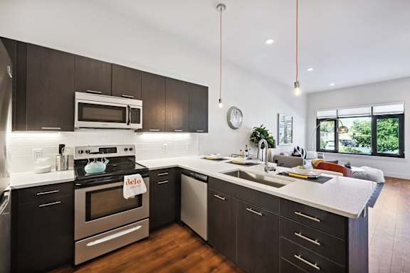 Modern kitchen with dark wood cabinets and stainless steel appliances at Delo Apartments, Louisville, CO, Colorado