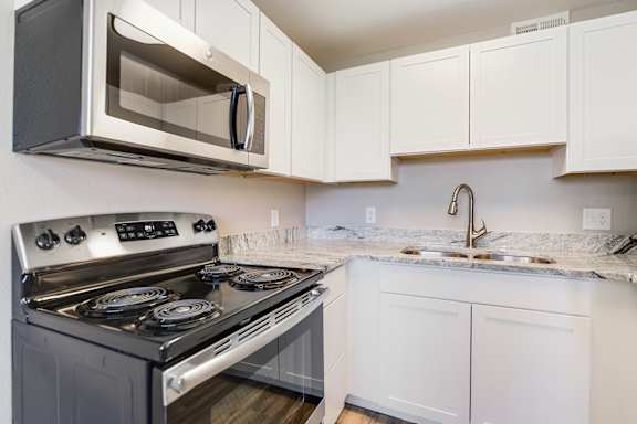 A modern kitchen with a stainless steel oven and microwave.