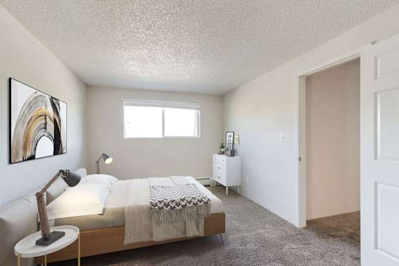 A bedroom with a bed, nightstand, and a painting on the wall.