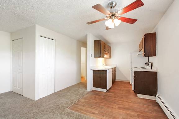 A room with a ceiling fan and wooden floors.