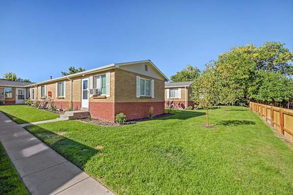A row of houses with green lawns in front.
