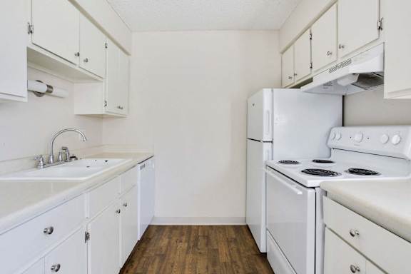 A kitchen with white appliances and cabinets.