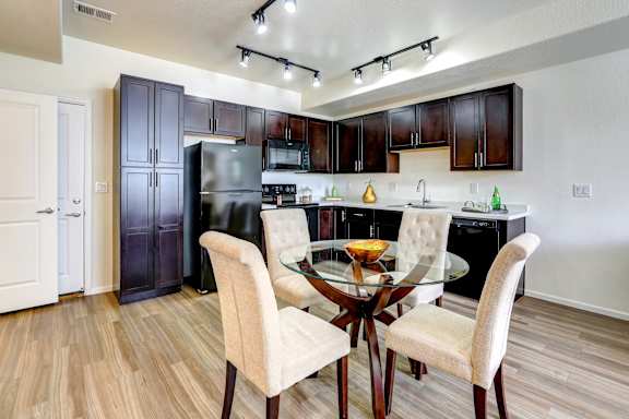 Modern kitchen with a glass dining table at Enclave Apartments, Henderson, Colorado