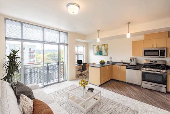 A modern living room with a kitchen area in the background.