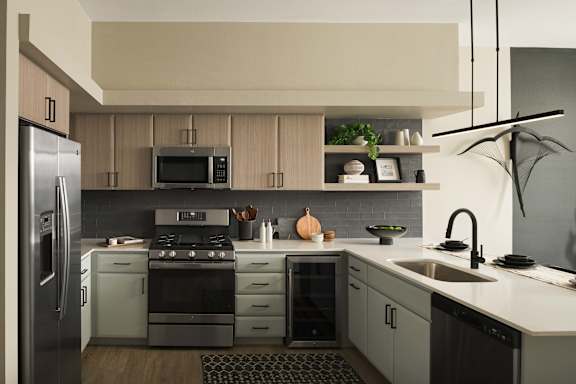 A modern kitchen with a refrigerator, stove, and sink.