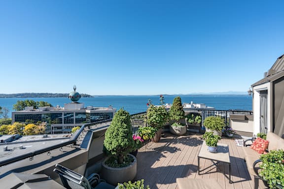 A balcony with a table and chairs overlooking a body of water.