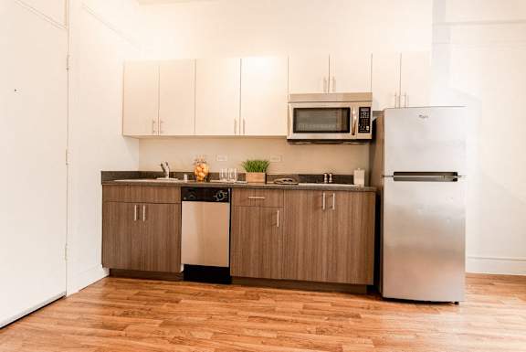 A kitchen with wooden cabinets and stainless steel appliances at Addison on Fourth Apartments, Washington