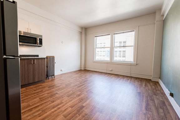 A kitchen with a refrigerator, oven, and microwave at Addison on Fourth Apartments, Seattle, WA
