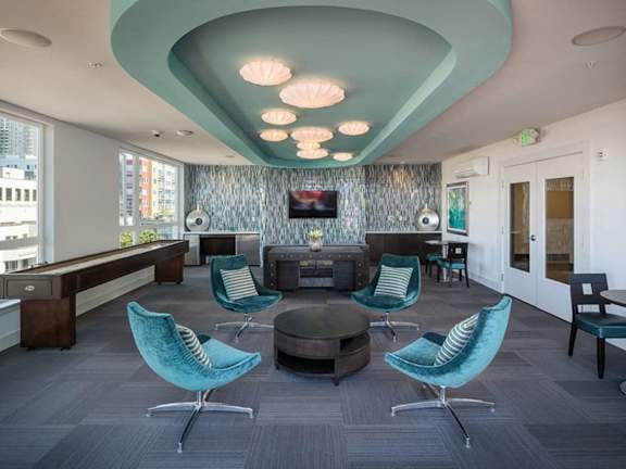 A modern office space with blue chairs and a grey carpet.