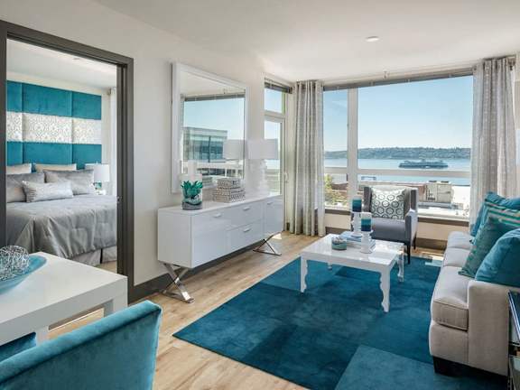 A modern living room with a large window overlooking the water.
