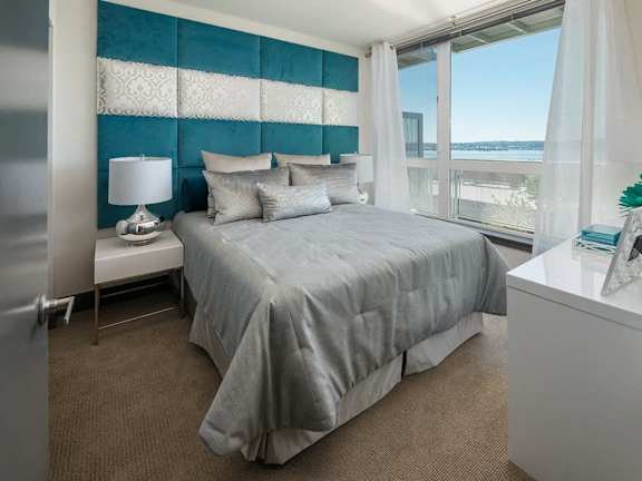 A bedroom with a large bed and a view of the water.