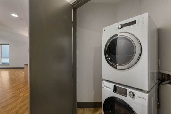 A white washing machine is stacked on top of another white washing machine.