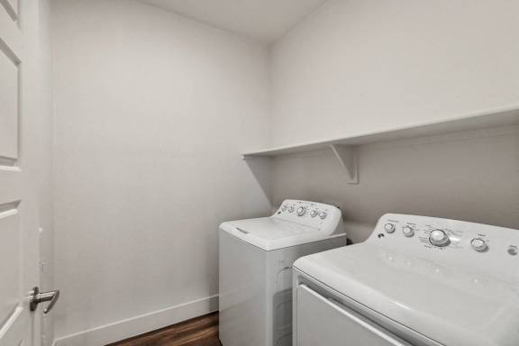 A white washing machine and dryer in a small laundry room.
